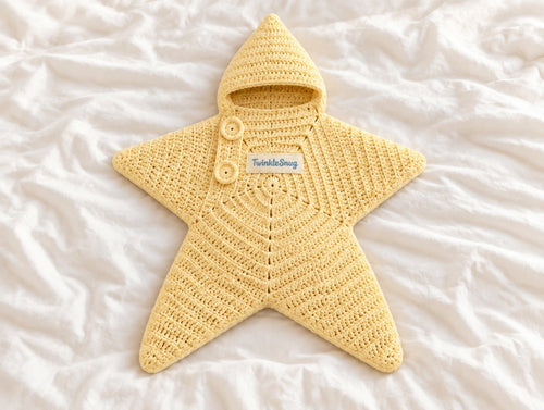 The Star Sleeping Bag in Butter Yellow, crocheted hooded star-shaped baby sleeping bag with TwinkleSnug tag